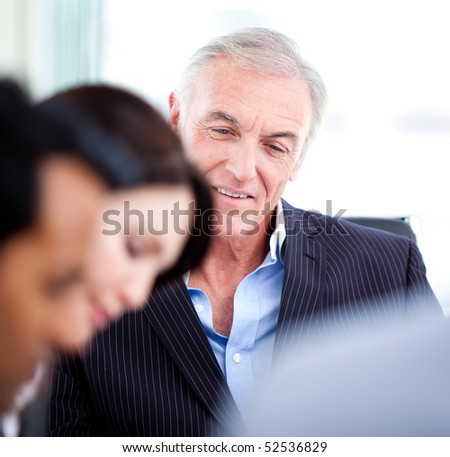 Confident senior businessman in a meeting with his team