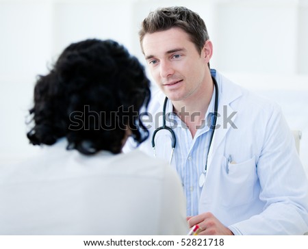 Handsome doctor talking with his patient for the annual check-up in the hospital