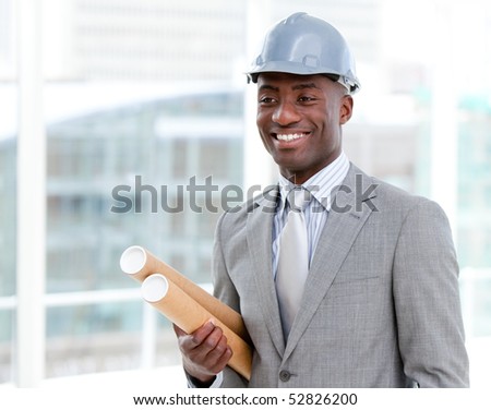 Portrait of a cheerful male architect holding blueprints in the office