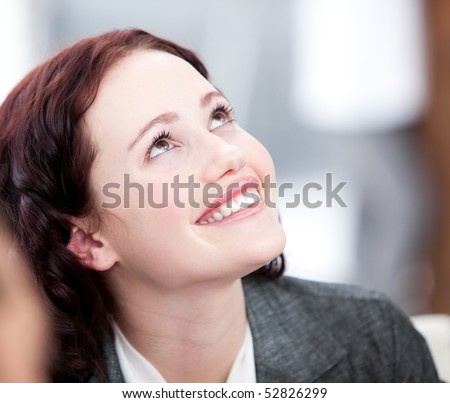 Radiant young buinesswoman smiling in a meeting with her team