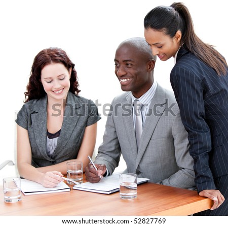 Smiling business co-workers studying a document in a meeting