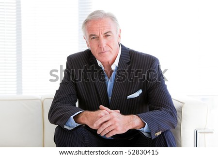 Charismatic senior businessman sitting on a sofa in the office