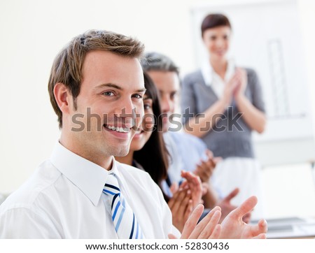 Smling business people applauding a good presentation in the office