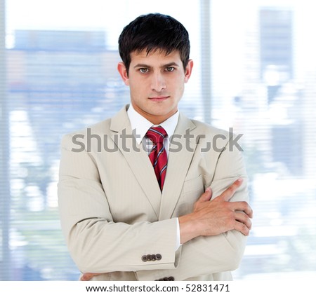 Self-assured businessman with folded arms standing in the office
