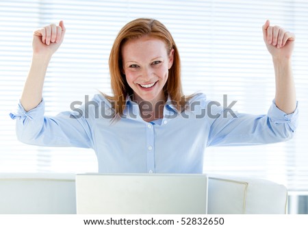 Bright business woman punching the air in the office