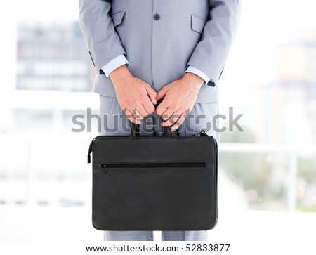 Mysterious businessman holding a briefcase in the office