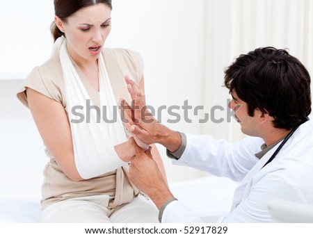 Professional male doctor examining the female patient by taking her arms in the hospital