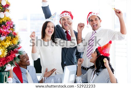 Business team punching the air to celebrate christmas in the office