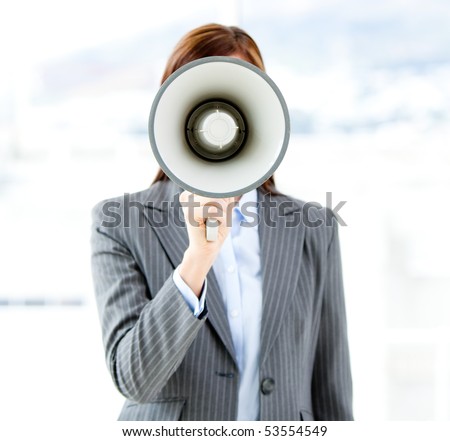 Portrait of an confident businesswoman using a megaphone in the office