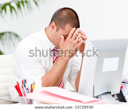 Frustrated businessman working at a computer in the office