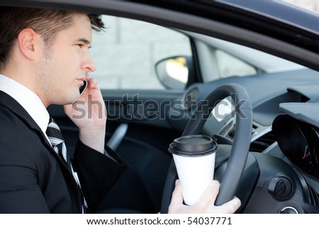 Cute businessman talking on the phone in a car