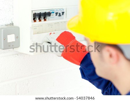 Mature electrician repairing a power plan at work