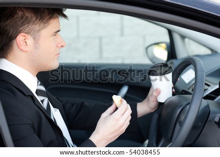 Handsome businessman talking on the phone in a car