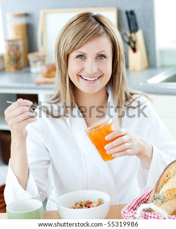 Delighted woman having a breakfast in the kitchen at home
