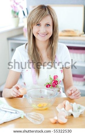 Delighted woman preparing a cake in the kitchen at home