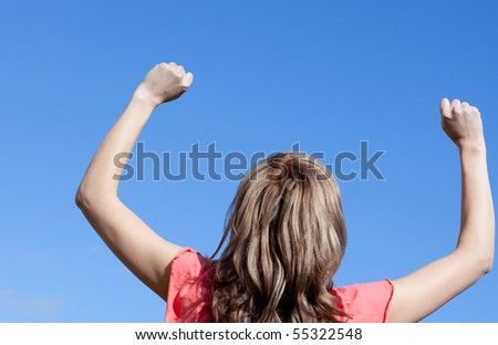 Happy woman punching the air outdoor against a blue sky background