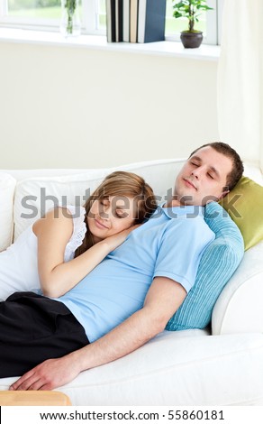 Affectionate couple sleeping lying on a sofa at home