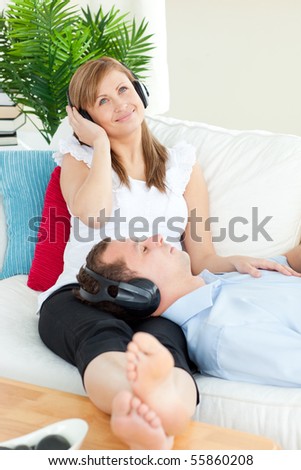 Cheerful woman relaxing with her boyfriend lying on a sofa at home