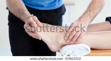 Close-up of a Caucasian physical therapist giving a foot massage in a health center