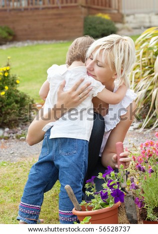 Shy girl embrace her mother in the garden