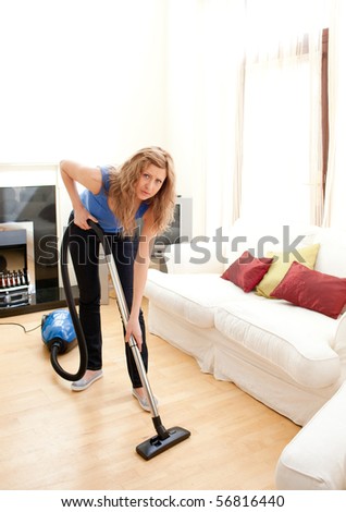 Charming woman use vacuum cleaner in a living room