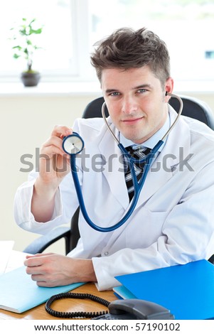 Handsome doctor holding a stethoscope looking at the camera