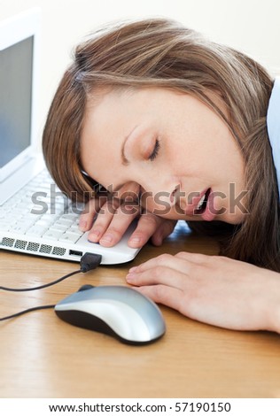 Young businesswoman sleeping on the keyboard in the office