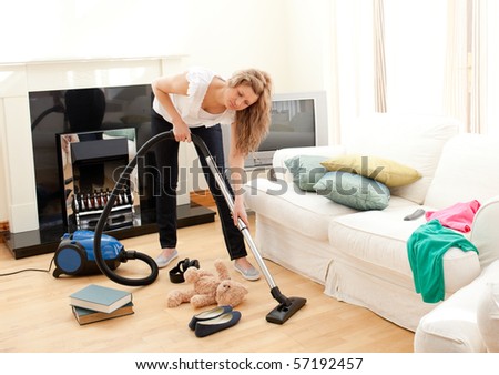 Portrait of a bored woman vacuuming at home