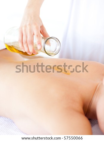 Beautiful woman having a massage with massage oil in a spa