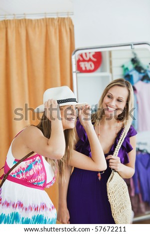 Smiling women choosing clothes together in a shop
