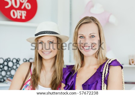 Cute women choosing clothes together in a shop