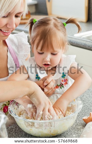 Happy mother and child baking cookies in the kitchen