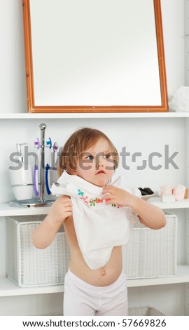 Small girl changing clothes in the bathroom