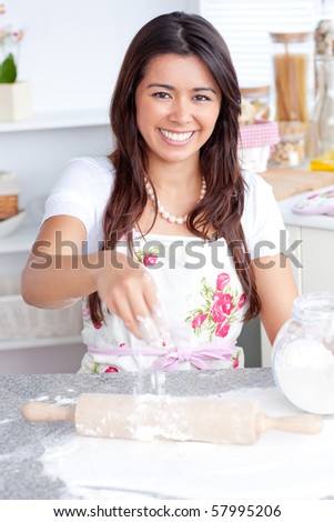 Captivating asian woman baking in her kitchen smiling at the camera