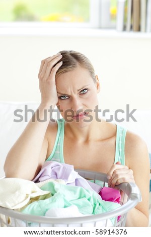 Exhausted young woman doing the laundry at home