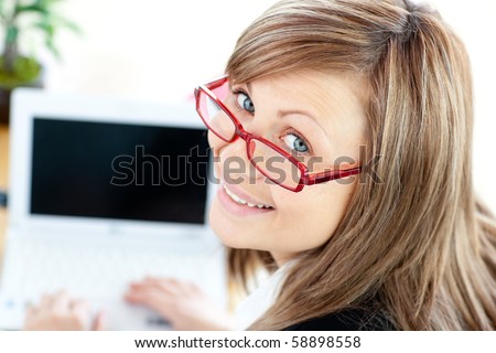 Animated businesswoman using her laptop looking at the camera in the office