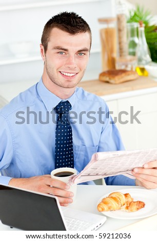 Handsome businessman reading the newspaper drinking coffee in the morning at home