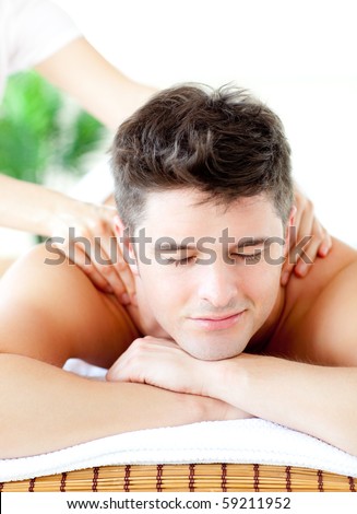 Portrait of a handsome man having a back massage in a spa center