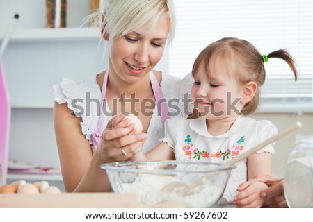 Happy mother and daughter baking together in the kitchen