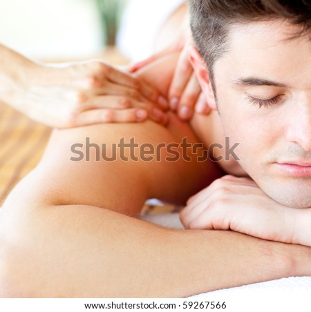 Close-up of an attractive man having a back massage in a spa center