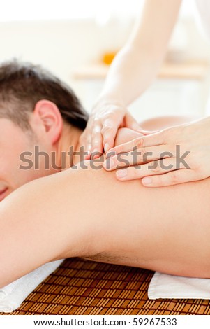 Caucasian young man enjoying a back massage in a spa center