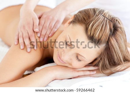 Delighted young woman having a back massage in a spa center