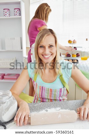 Beautiful caucasian woman baking together with her friend at home in the kitchen