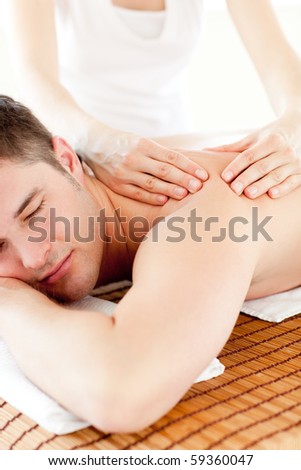 Positive caucasian man having a back massage in a spa center