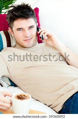 Handsome young man talking on phone at home smiling at the