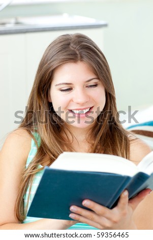 Bright caucasian woman reading a book at home sitting on a sofa