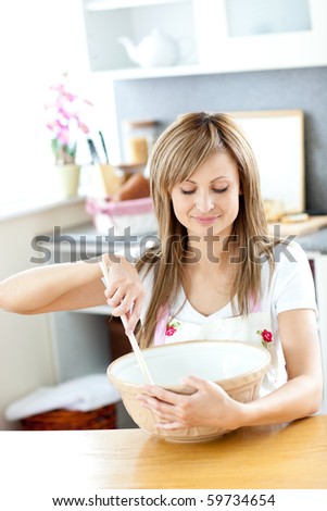 Portrait of a cute woman cooking a cake in the kitchen at home