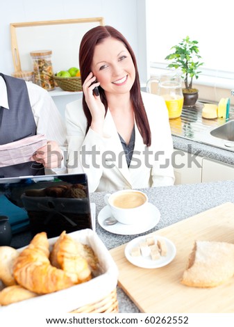 Busy couple of businesspeople having breakfast in the kitchen at home