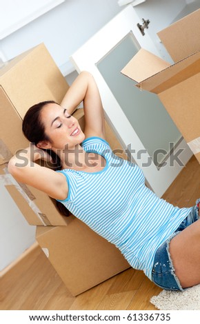 Relaxing woman sitting on the floor after unpacking boxes in her new location