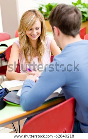Portrait of a self-assured student working with her friend in the cafeteria of their university